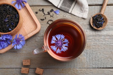 Flat lay composition with tea and cornflowers on wooden table