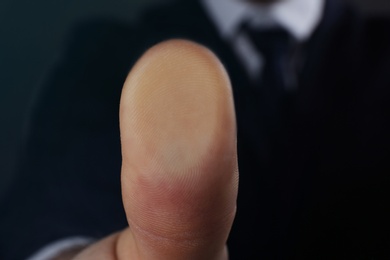 Businessman pressing control glass of biometric fingerprint scanner, closeup. Space for text