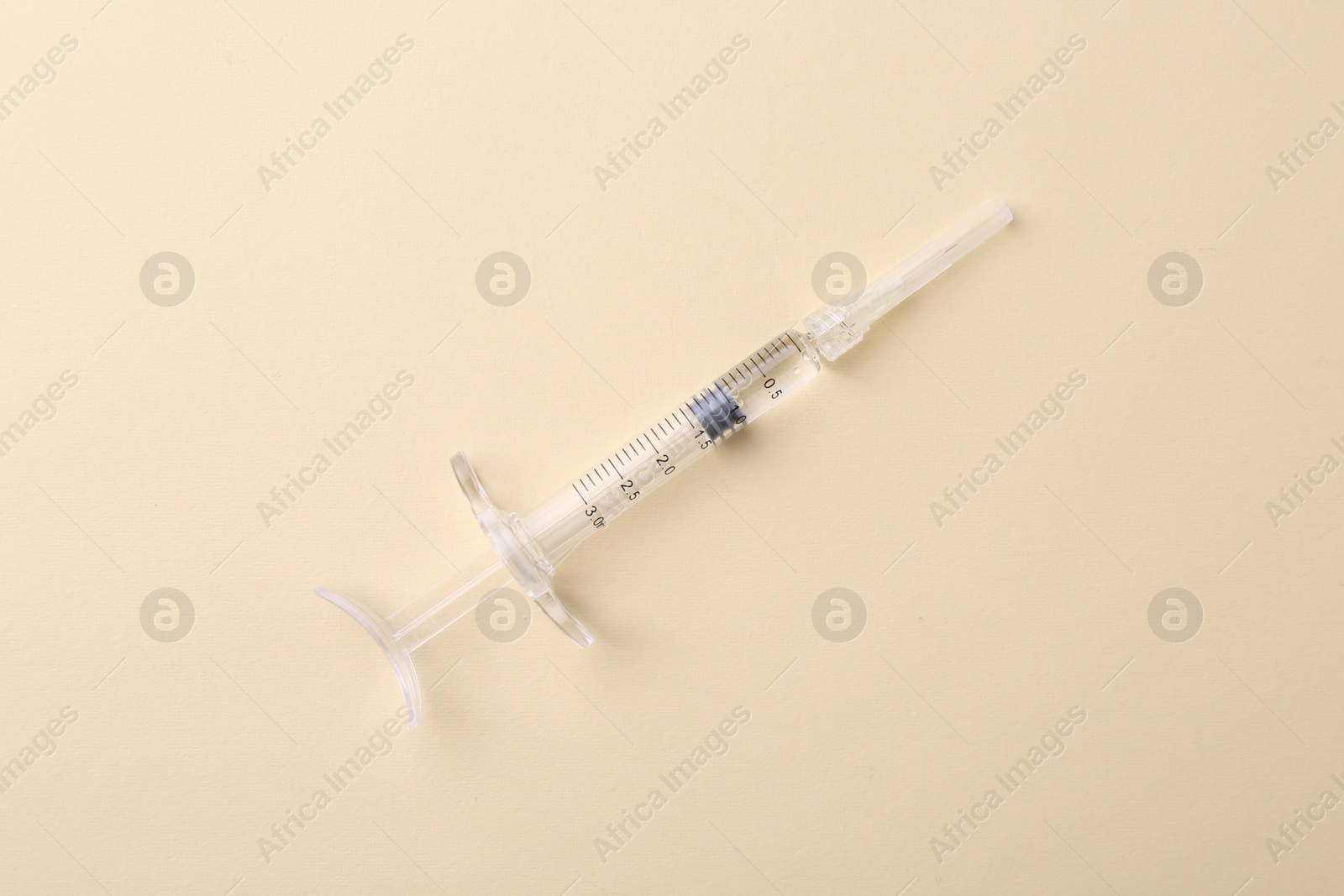 Photo of Injection cosmetology. One medical syringe on beige background, top view