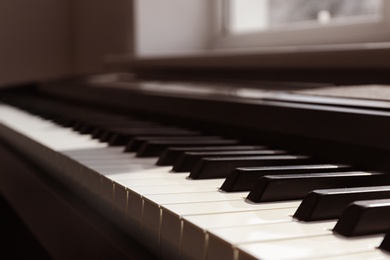 Photo of Modern piano with black and white keys indoors, closeup