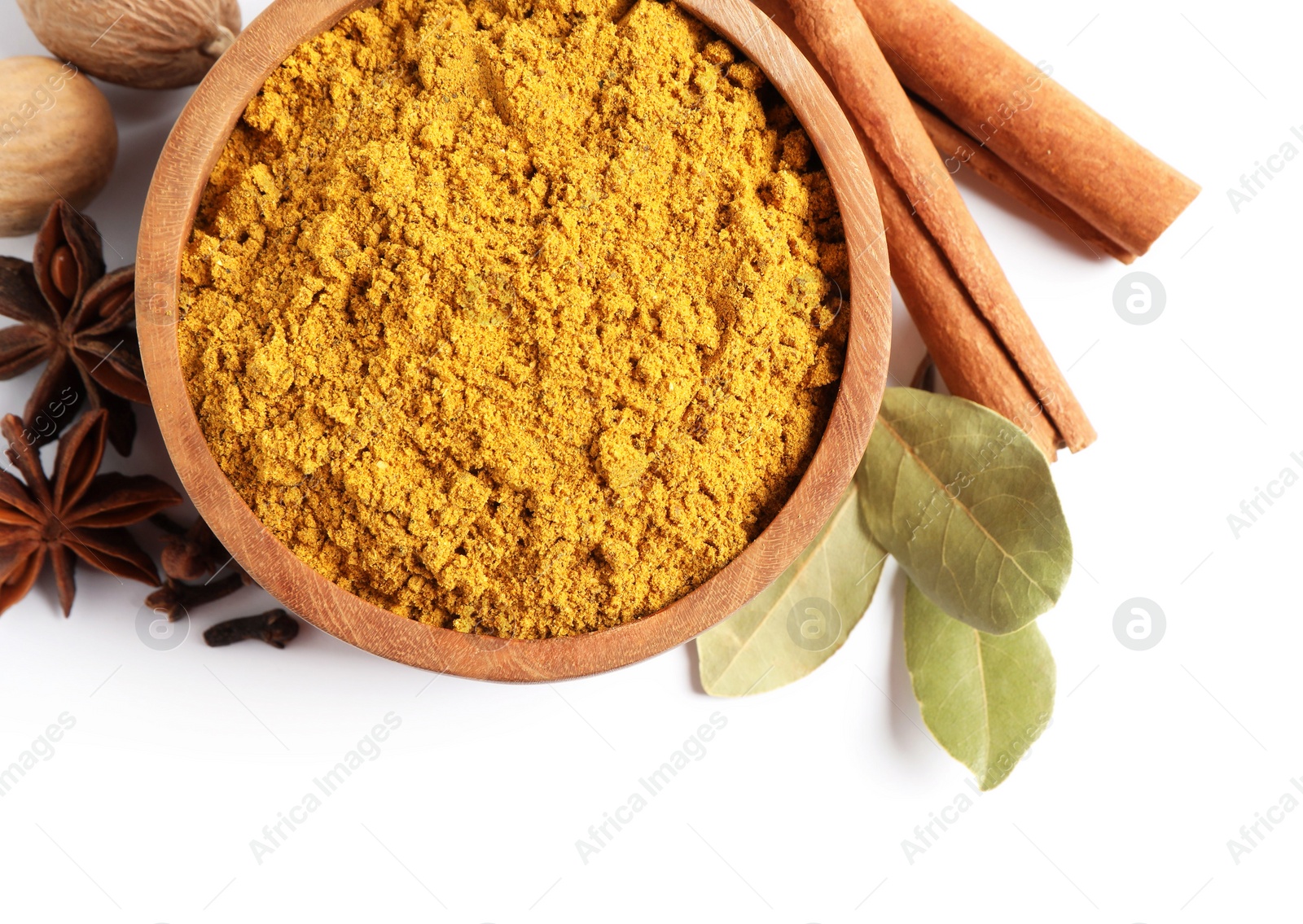 Photo of Dry curry powder in bowl and other spices isolated on white, top view