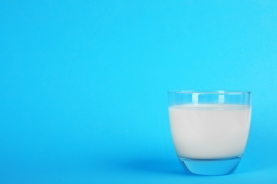 Photo of Glass with fresh milk on color background. Space for text