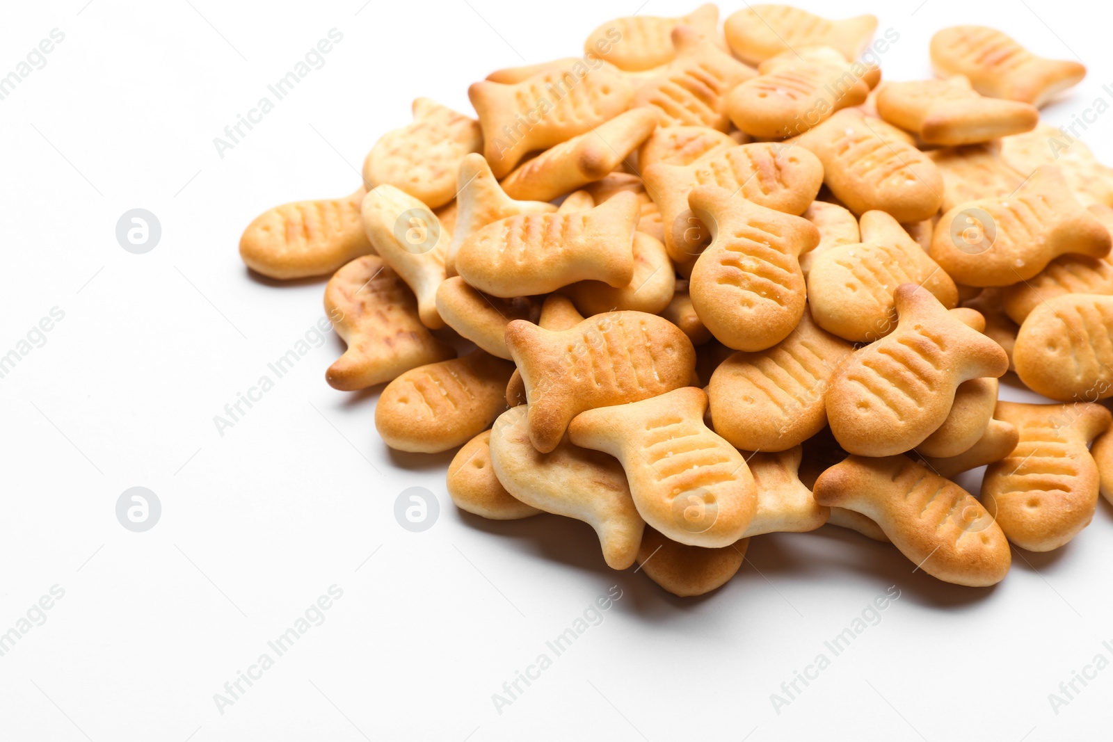 Photo of Delicious crispy goldfish crackers on white background, closeup