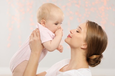 Photo of Portrait of happy mother with her baby against blurred lights