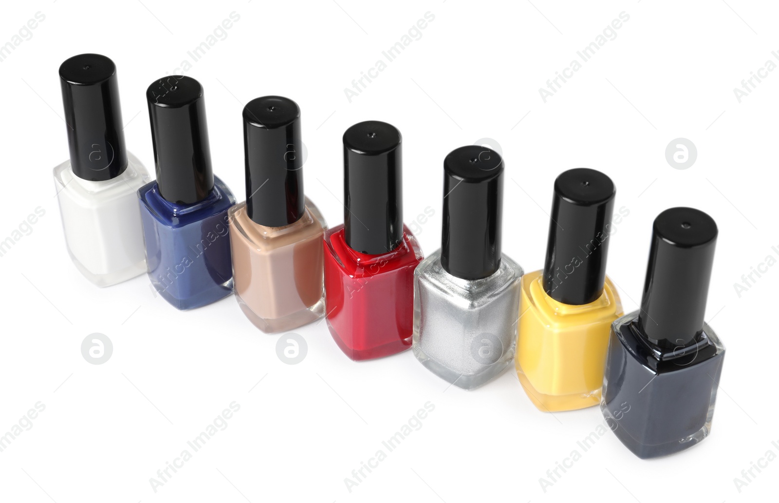 Photo of Bright nail polishes in bottles isolated on white