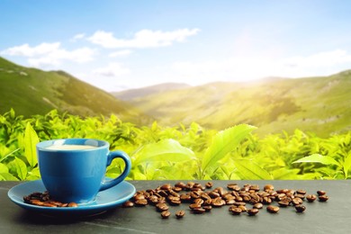 Image of Cup of aromatic hot coffee on black table and beautiful view of mountain landscape. Space for text