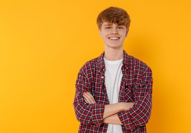 Photo of Portrait of teenage boy on orange background. Space for text