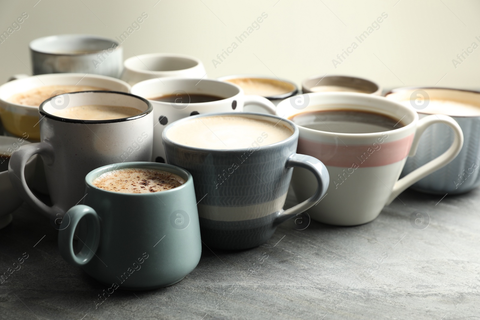 Photo of Many cups of different coffees on slate table
