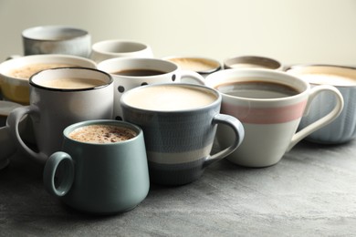 Photo of Many cups of different coffees on slate table