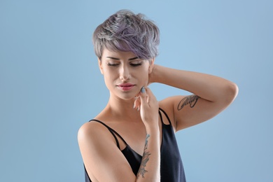 Photo of Young woman with tattoos on color background