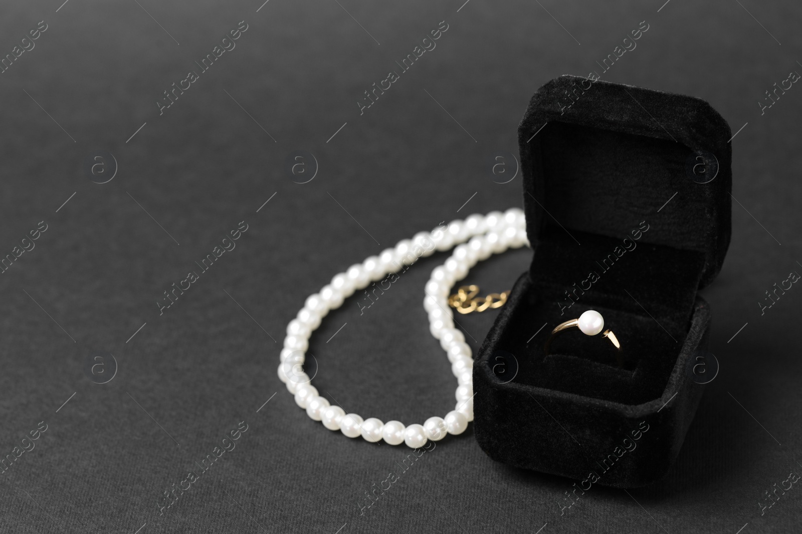 Photo of Jewelry box with ring and necklace on dark gray background, space for text