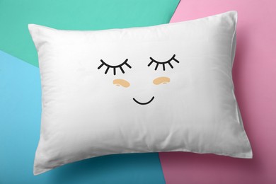 Image of Soft pillow with cute face on color background, top view