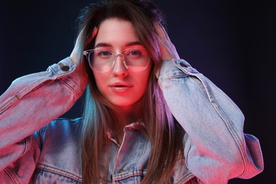 Photo of Portrait of beautiful young woman in glasses on color background
