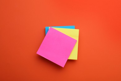 Photo of Paper notes on orange background, top view