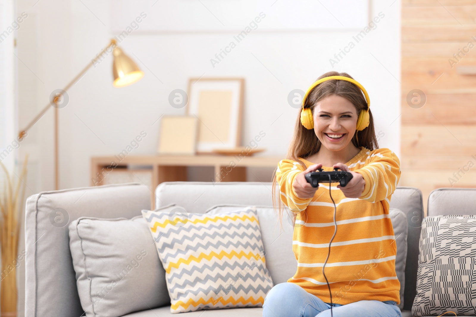 Photo of Emotional young woman playing video games at home