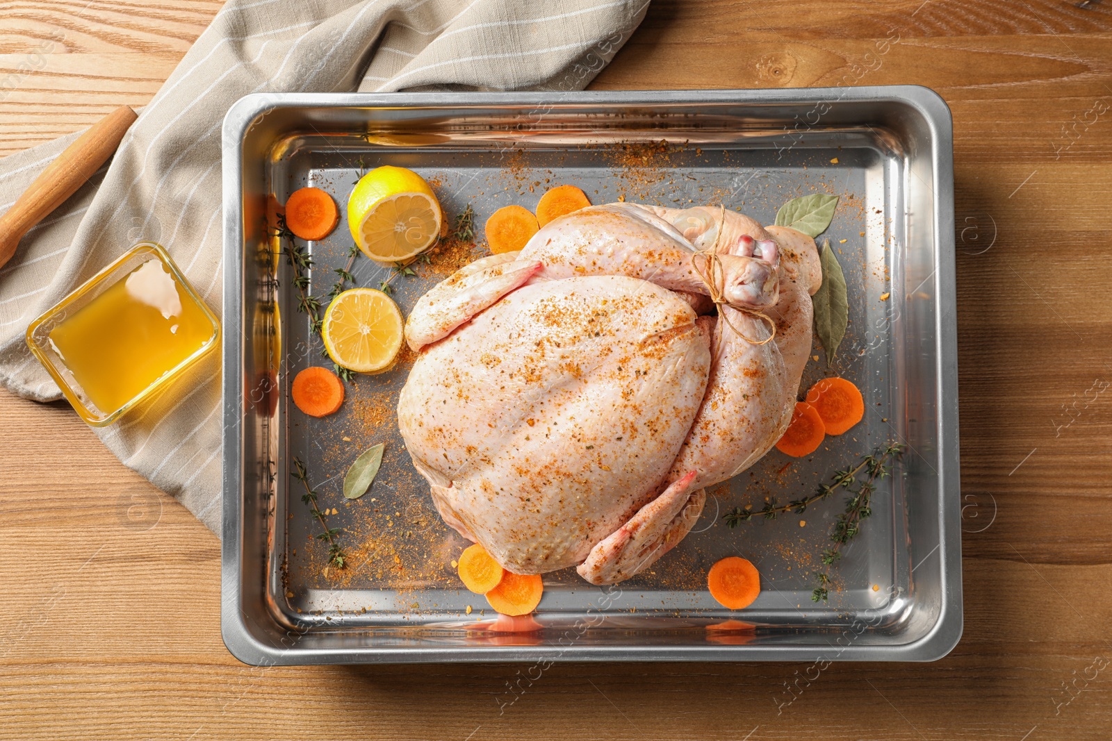 Photo of Dish with raw spiced turkey on wooden background, top view