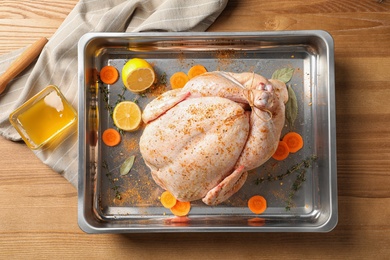 Dish with raw spiced turkey on wooden background, top view