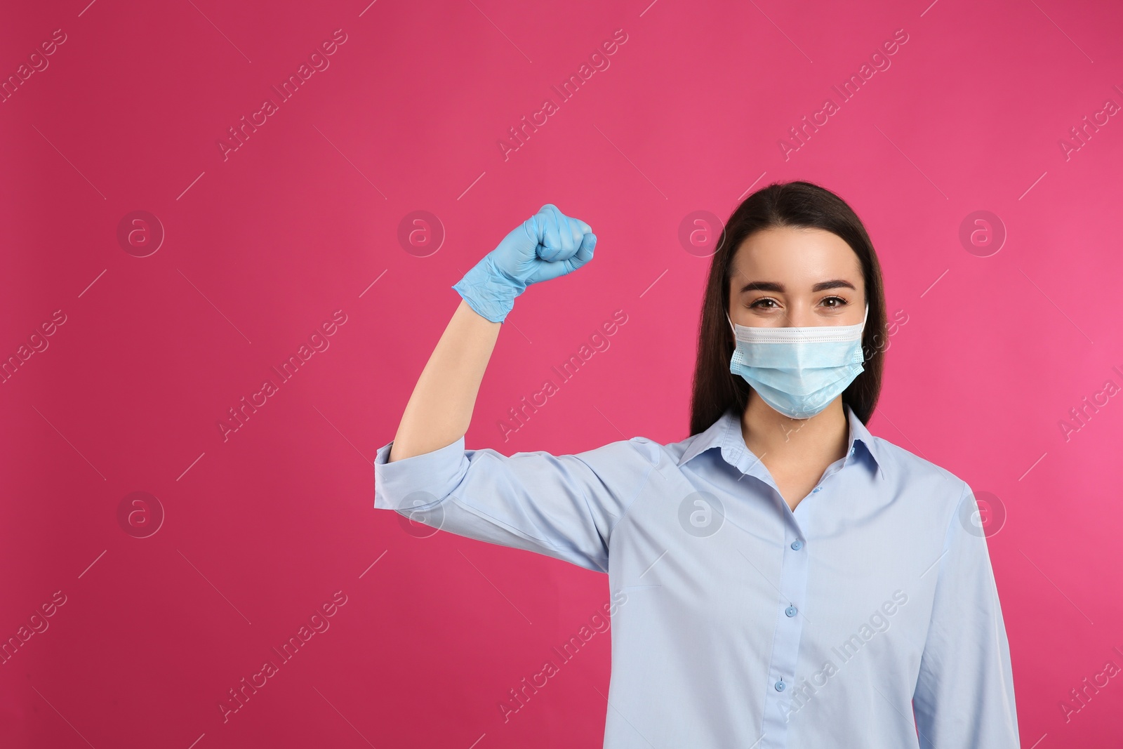 Photo of Woman with protective mask and gloves showing muscles on pink background, space for text. Strong immunity concept