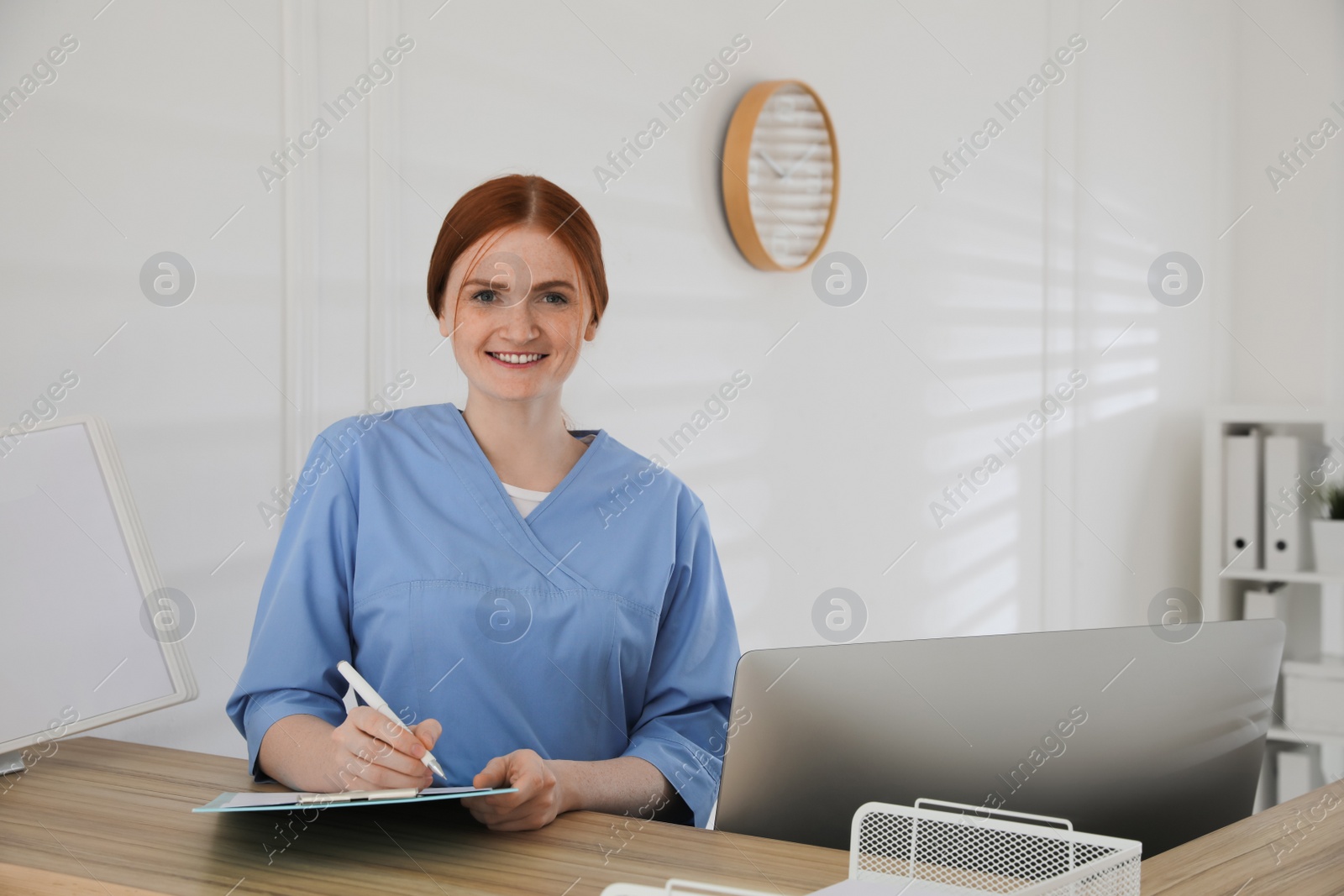 Photo of Receptionist with clipboard at countertop in hospital, space for text