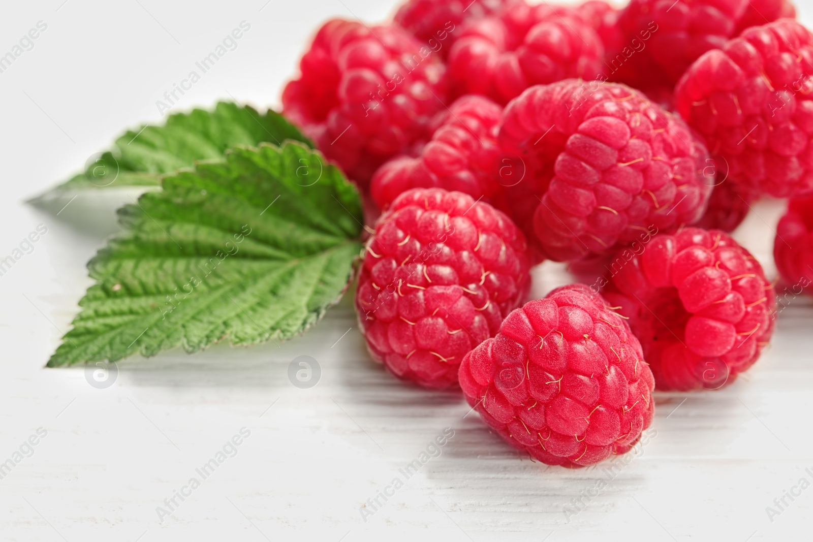 Photo of Ripe aromatic raspberries on wooden table