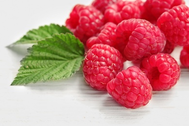 Ripe aromatic raspberries on wooden table