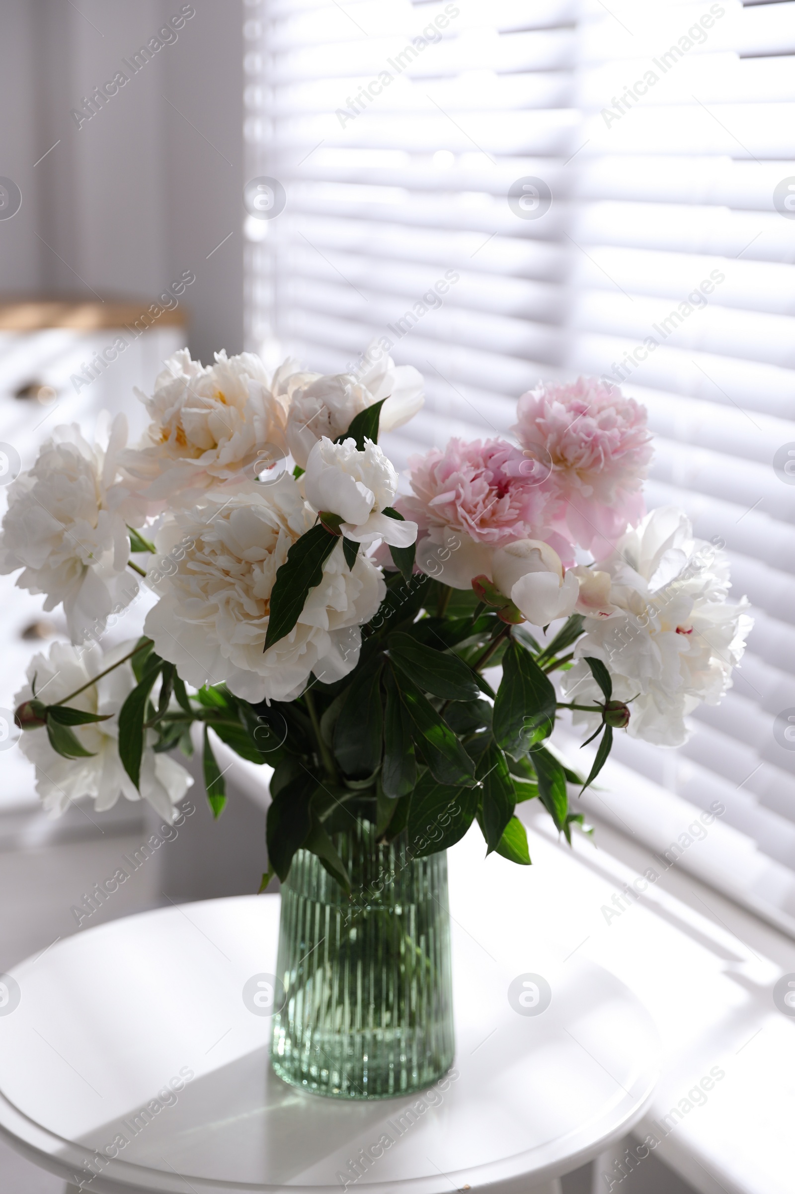 Photo of Bouquet of beautiful peony flowers on table indoors