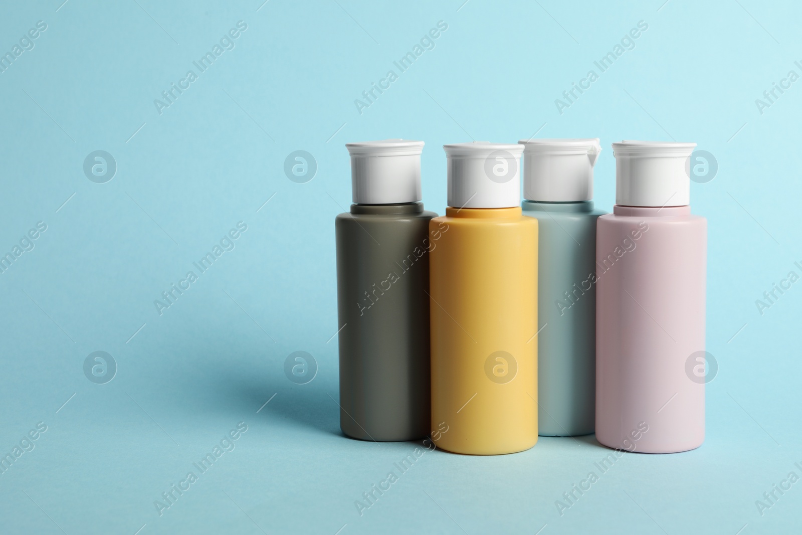 Photo of Cosmetic travel kit on light blue background. Bath accessories. Space for text