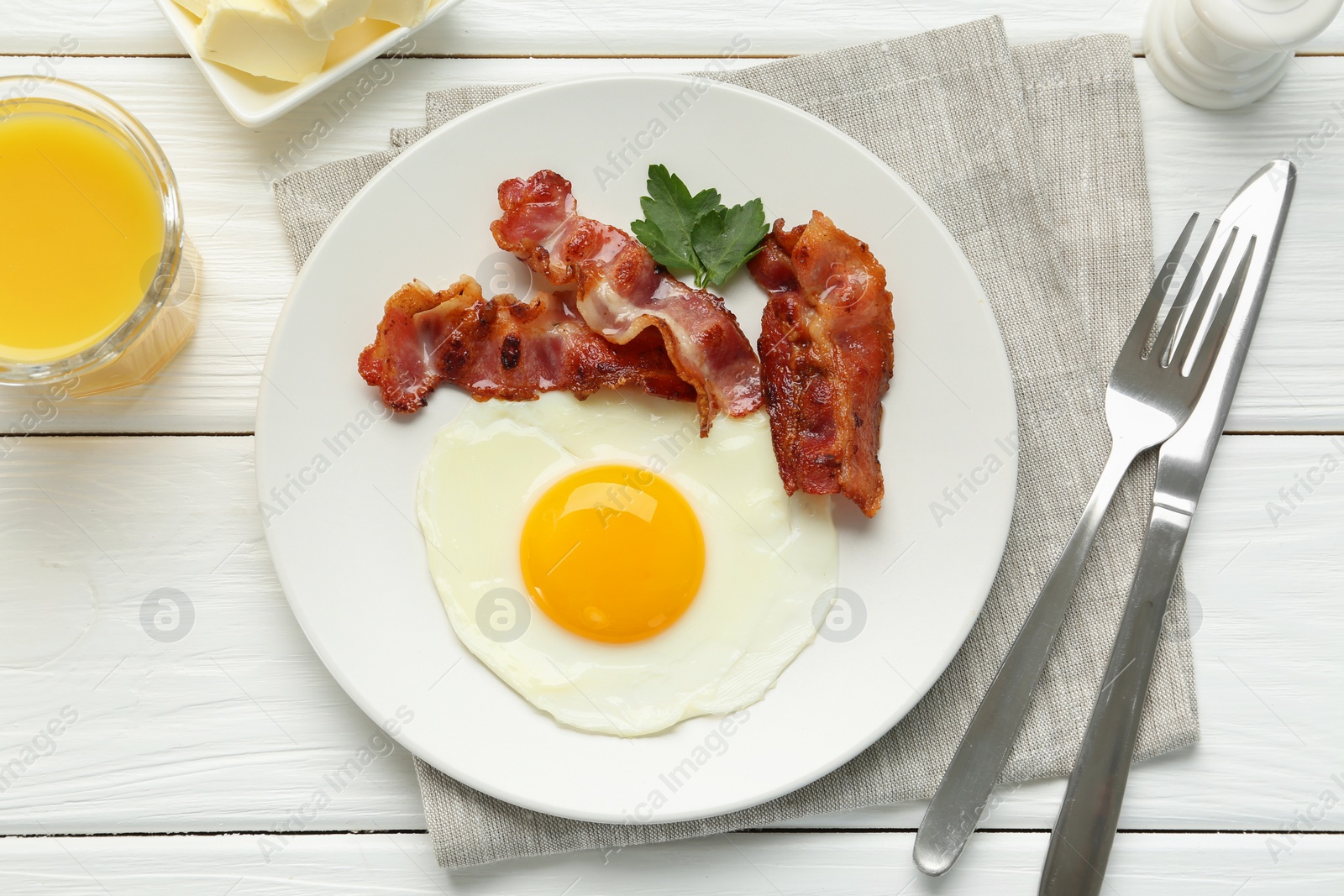 Photo of Delicious breakfast with sunny side up egg served on white wooden table, flat lay