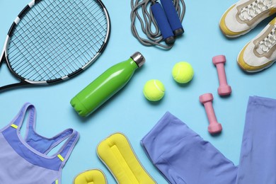 Photo of Flat lay composition with sports equipment on light blue background
