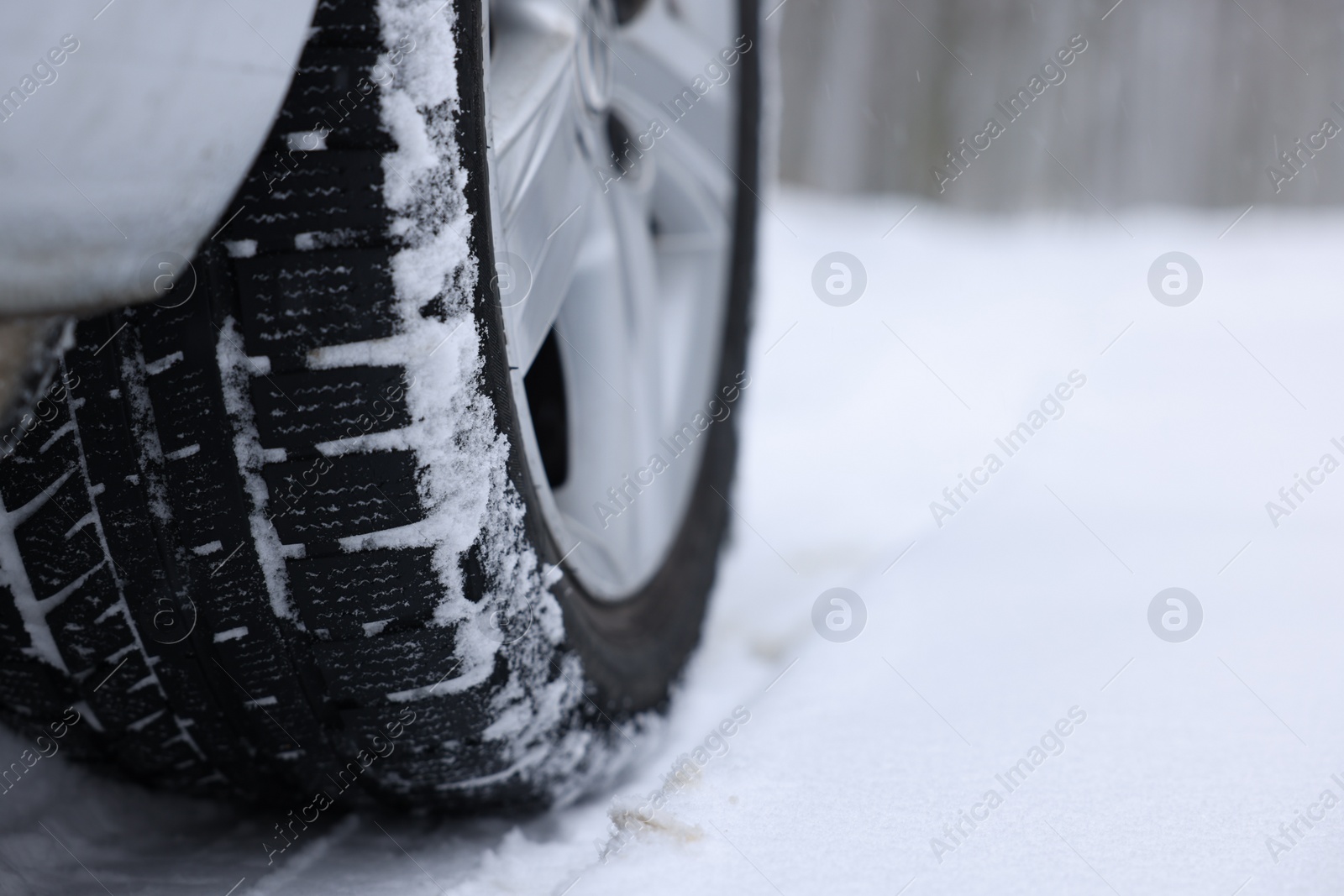 Photo of Car with winter tires on snowy road outdoors, closeup. Space for text