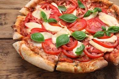 Delicious Caprese pizza on wooden table, closeup