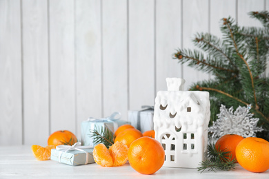 Photo of Fresh tangerines and Christmas decoration on white wooden table