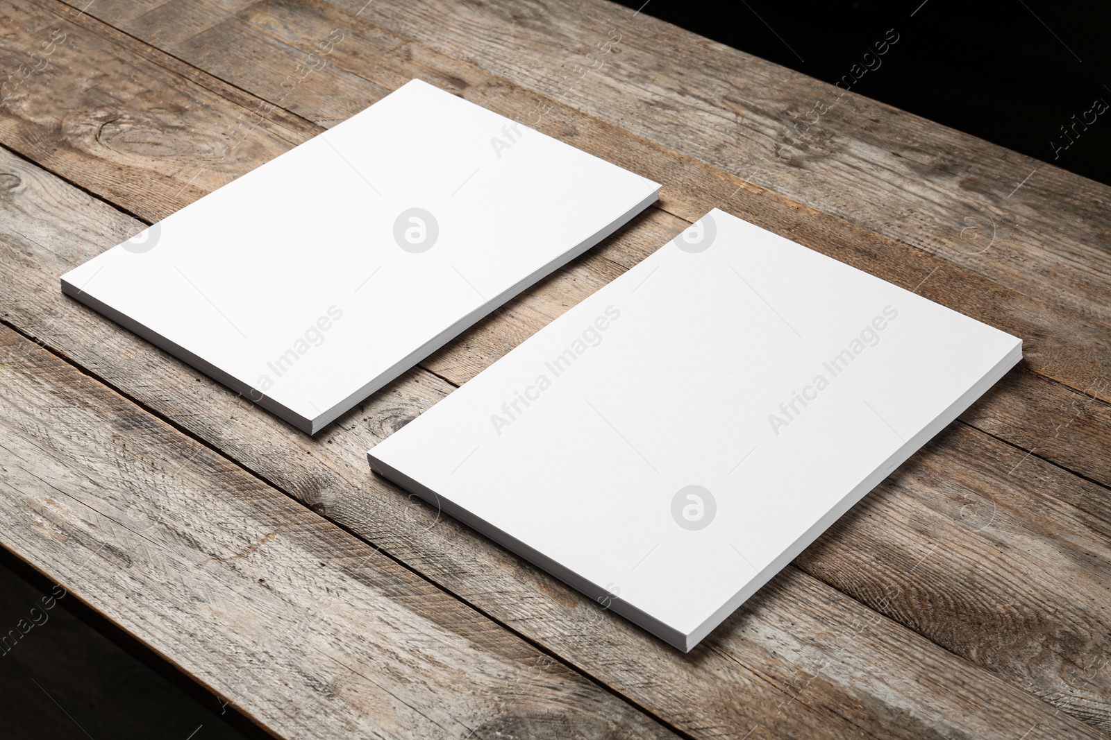 Photo of Blank paper sheets for brochure on wooden background. Mock up