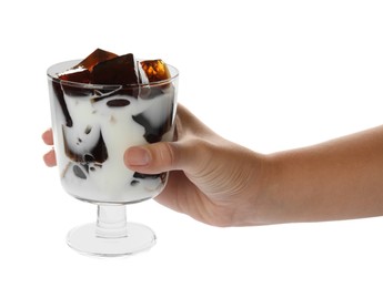 Photo of Woman holding glass of milk with delicious grass jelly on white background, closeup