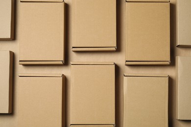 Many closed cardboard boxes on light brown background, flat lay