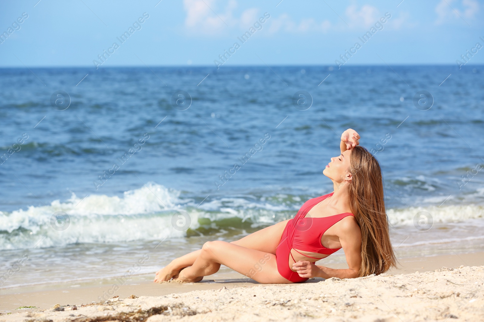 Photo of Attractive young woman in beautiful one-piece swimsuit on beach