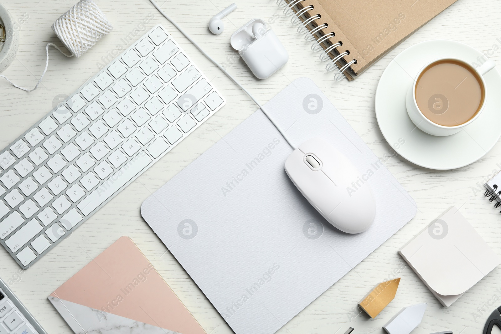 Photo of Flat lay composition with wired computer mouse, keyboard and stationery on white wooden table