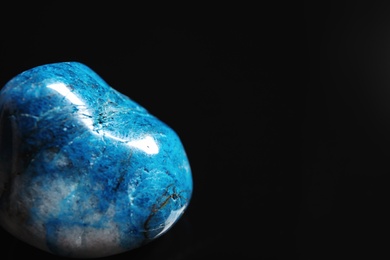 Photo of Beautiful blue shattuckite gemstone on black background, closeup. Space for text