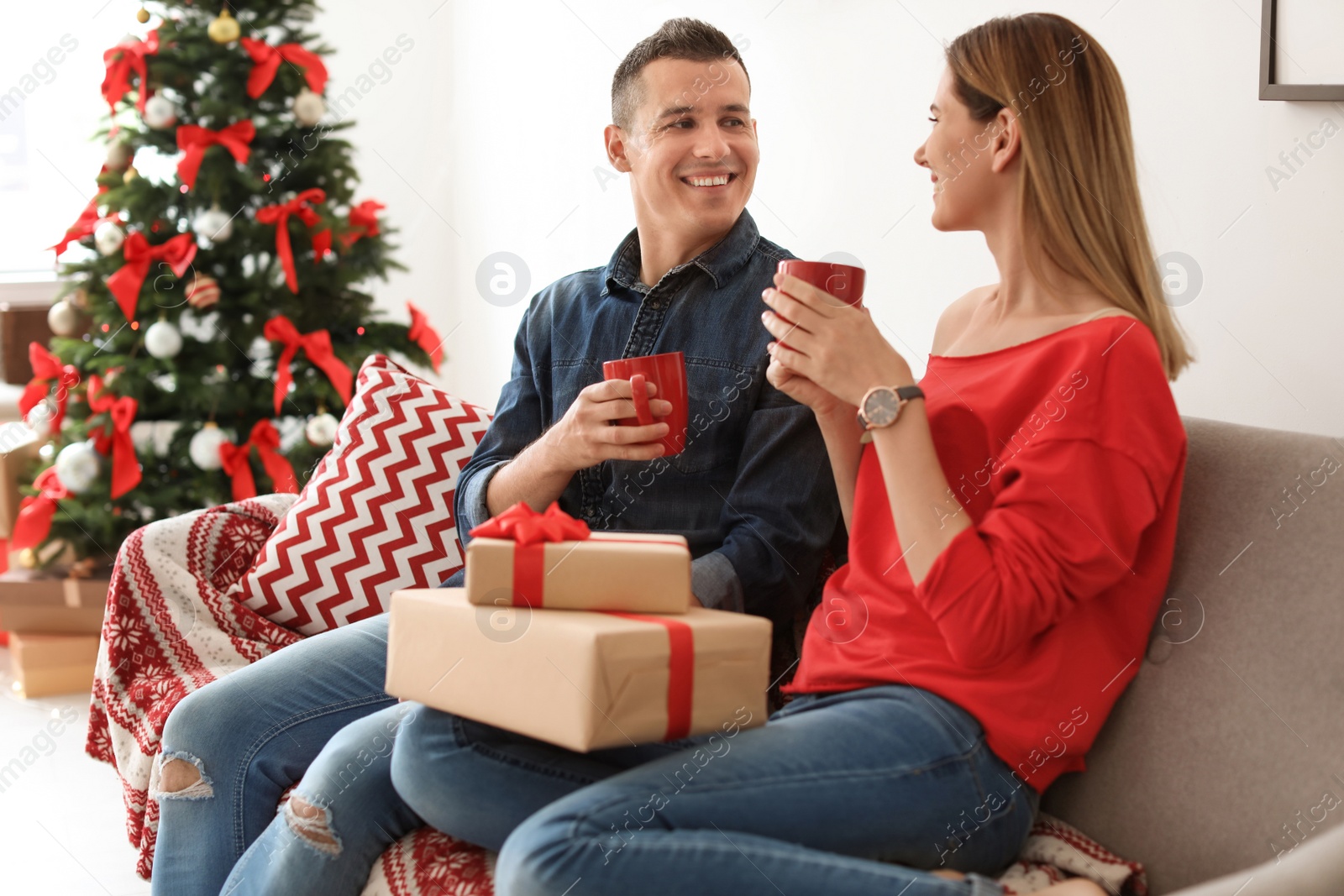 Photo of Young couple with Christmas gifts at home