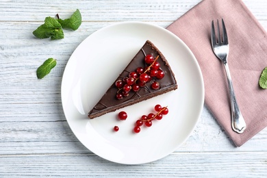 Photo of Flat lay composition with slice of tasty chocolate cake on wooden table