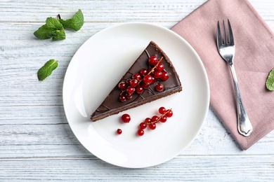 Flat lay composition with slice of tasty chocolate cake on wooden table