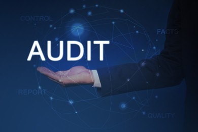 Image of Audit concept. Businessman holding digital word in hand and scheme on blue background, closeup