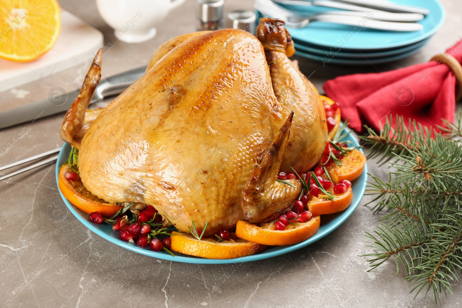 Photo of Delicious chicken with oranges and pomegranate on grey table