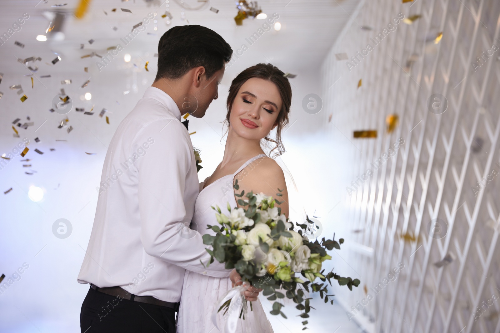 Photo of Happy newlywed couple dancing together in festive hall