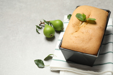 Photo of Tasty bread with mint and pears on light grey table. Homemade cake