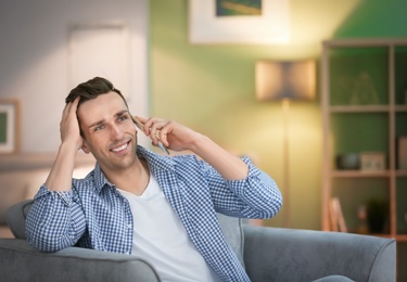 Photo of Young man talking on phone at home