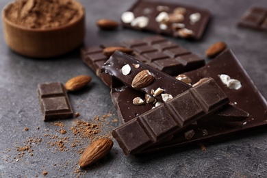 Photo of Delicious chocolate with nuts on dark table, closeup