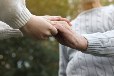 Photo of Trust and support. Woman with man joining hands outdoors, low angle view