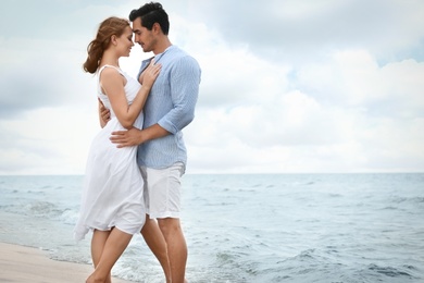 Happy young couple spending time at sea beach