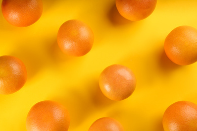 Tasty ripe grapefruits on yellow background, flat lay